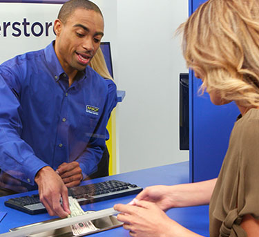 Un empleado de Amscot ayudando a un cliente